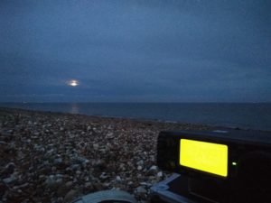 Glowing radio in the foreground and moon low in the sky