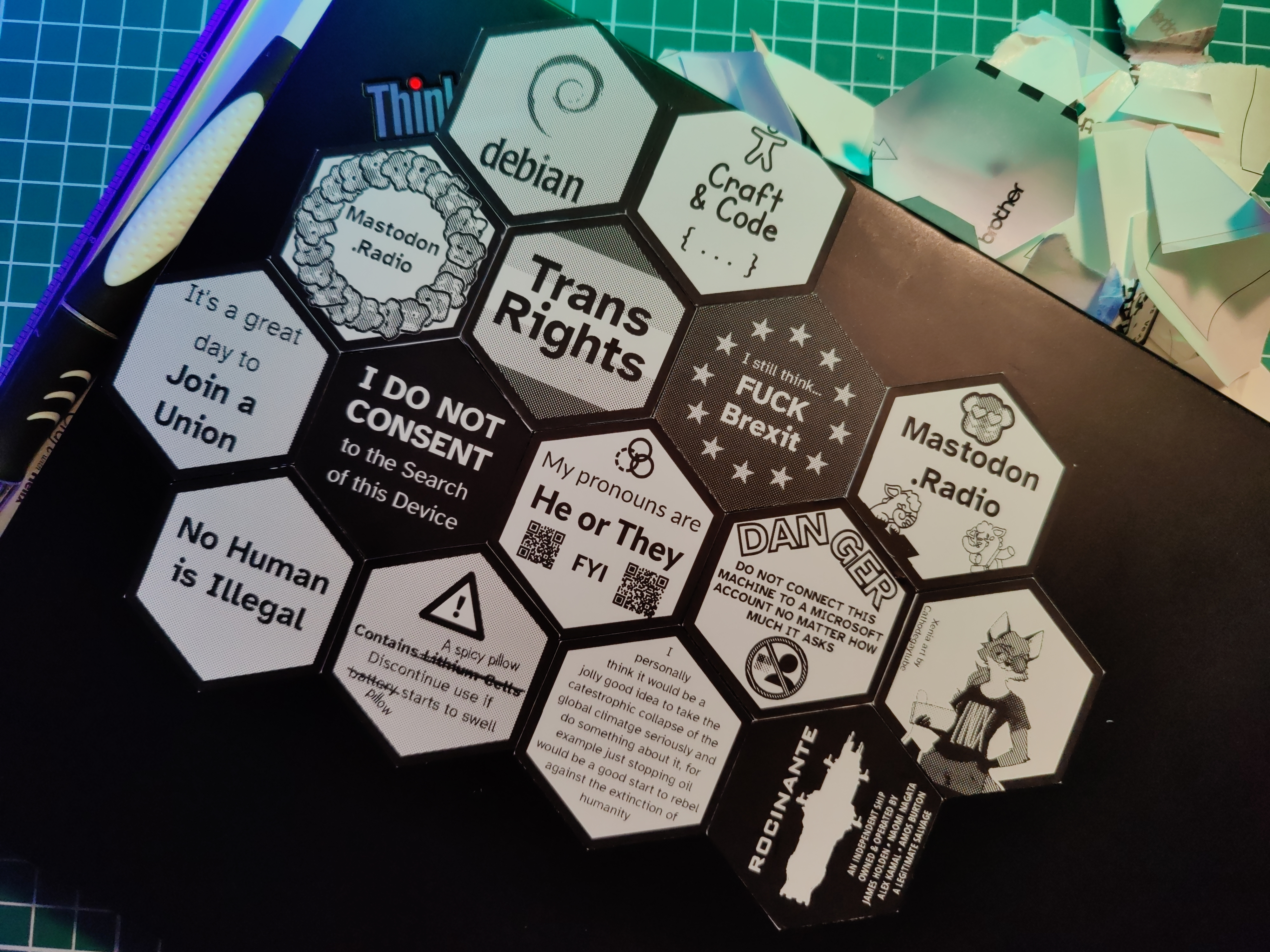 My ThinkBook with a tesselation of stickers applied - aligned with and overlapping the ThinkBook logo